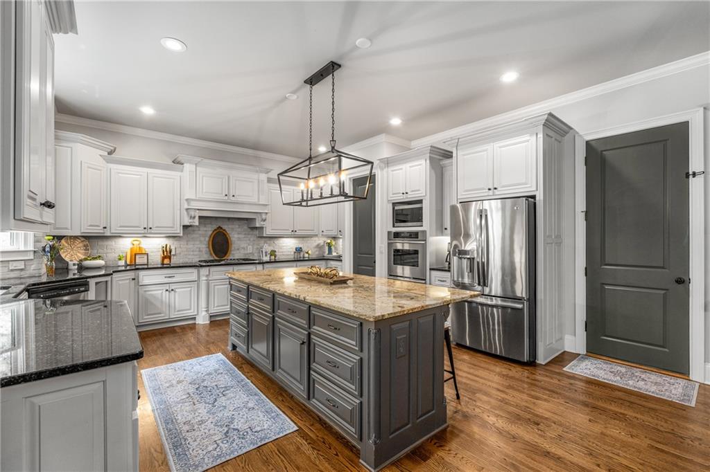5605 Copper Creek Pass Cumming, GA 30040 - Photo 17 of 64 a kitchen with stainless steel appliances granite countertop a sink a stove a refrigerator and island