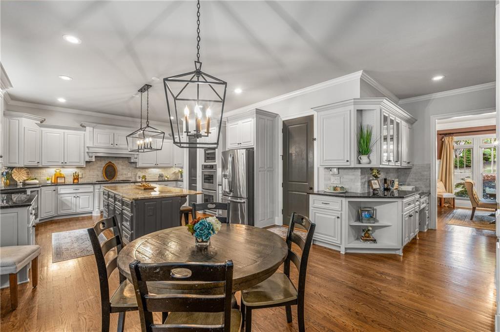 5605 Copper Creek Pass Cumming, GA 30040 - Photo 21 of 64 a view of a dining room with furniture a kitchen and chandelier