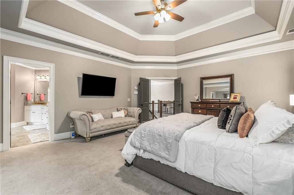 5605 Copper Creek Pass Cumming, GA 30040 - Photo 33 of 64 a bedroom with a large bed a flat screen tv and a couch