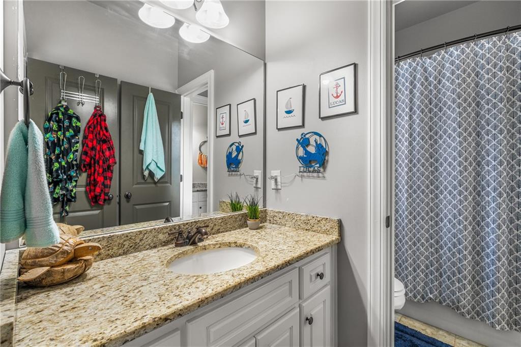 5605 Copper Creek Pass Cumming, GA 30040 - Photo 40 of 64 a bathroom with a granite countertop sink and a mirror