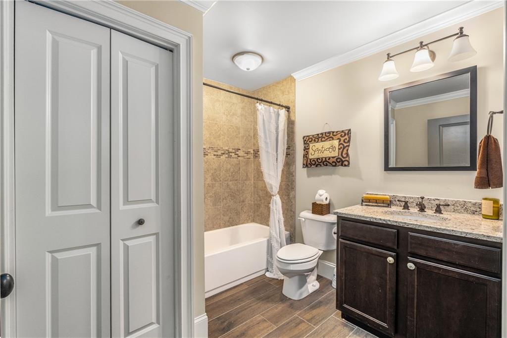 5605 Copper Creek Pass Cumming, GA 30040 - Photo 48 of 64 a bathroom with a toilet sink a mirror a vanity and shower