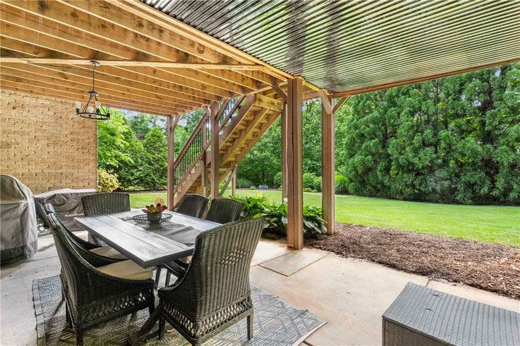5605 Copper Creek Pass Cumming, GA 30040 - Photo 50 of 64 a view of a patio with a table and chairs under an umbrella