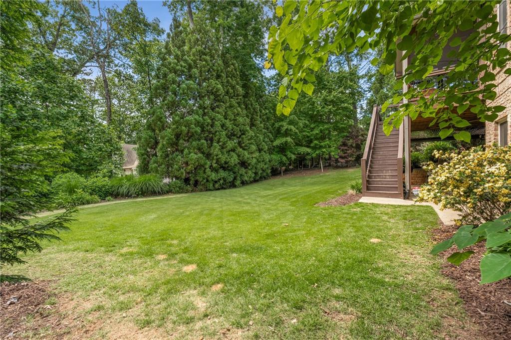 5605 Copper Creek Pass Cumming, GA 30040 - Photo 51 of 64 a view of a backyard with a plants and large trees