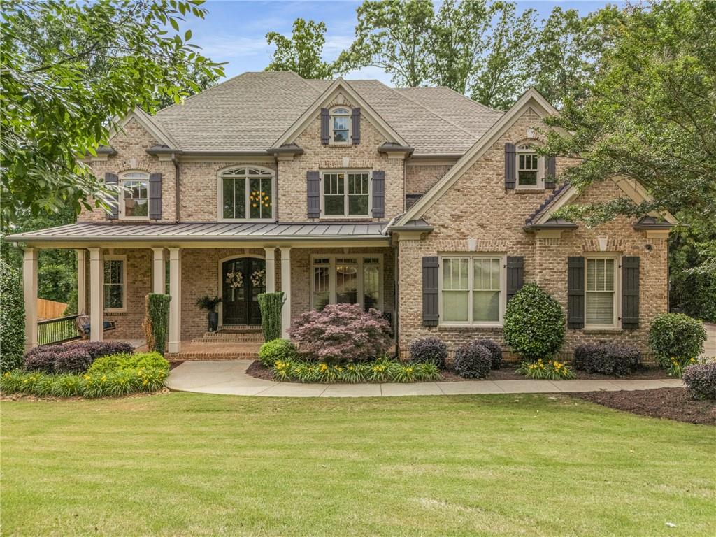 5605 Copper Creek Pass Cumming, GA 30040 - Photo 60 of 64 a front view of a house with a yard table and chairs