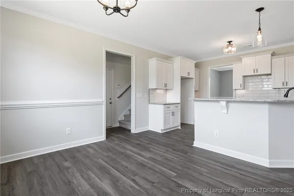 a view of a kitchen with wooden floor and electronic appliances