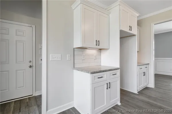a kitchen with white cabinets and refrigerator
