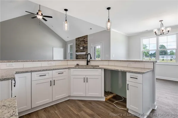 a spacious bathroom with a granite countertop sink mirror and cabinets