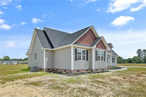 a view of a house with a yard and a large tree