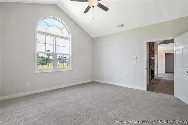 an empty room with windows and ceiling fan