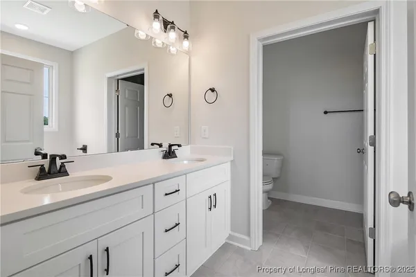 a bathroom with a double vanity sink a mirror and a shower