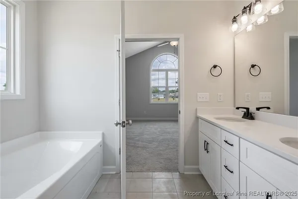 a spacious bathroom with a granite countertop sink a mirror bathtub and shower