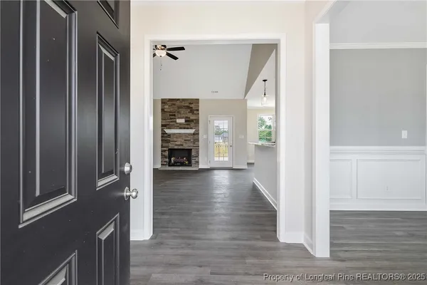 a view of a hallway with wooden floor and staircase