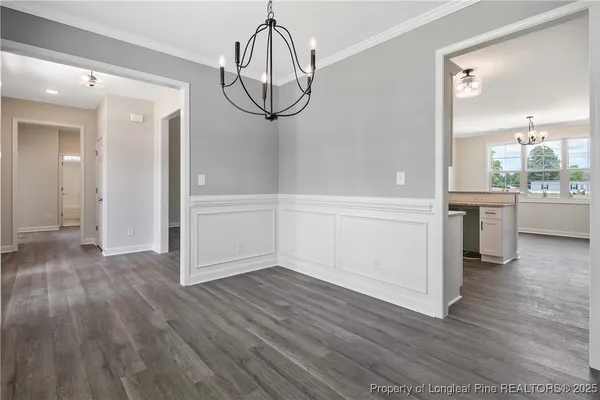a view of a room with wooden floor cabinets and a kitchen
