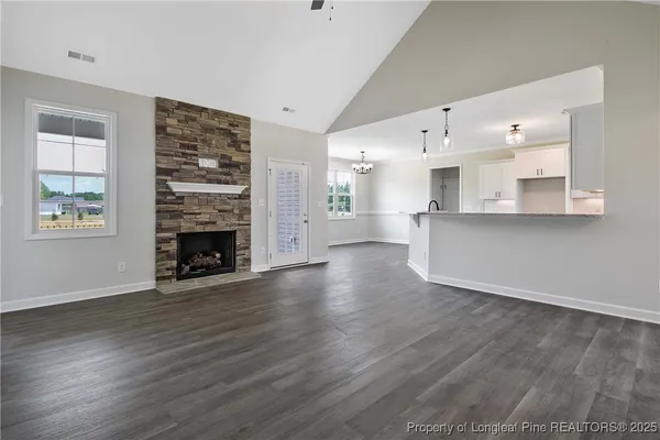 a view of a living room a kitchen with wooden floor and a fireplace
