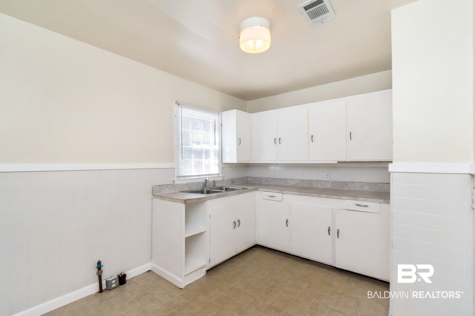 1477 Fairfield Street Mobile, AL 36606 - Photo 15 of 34 Kitchen featuring wainscoting, light countertops, white cabinetry, tile walls, and light floors