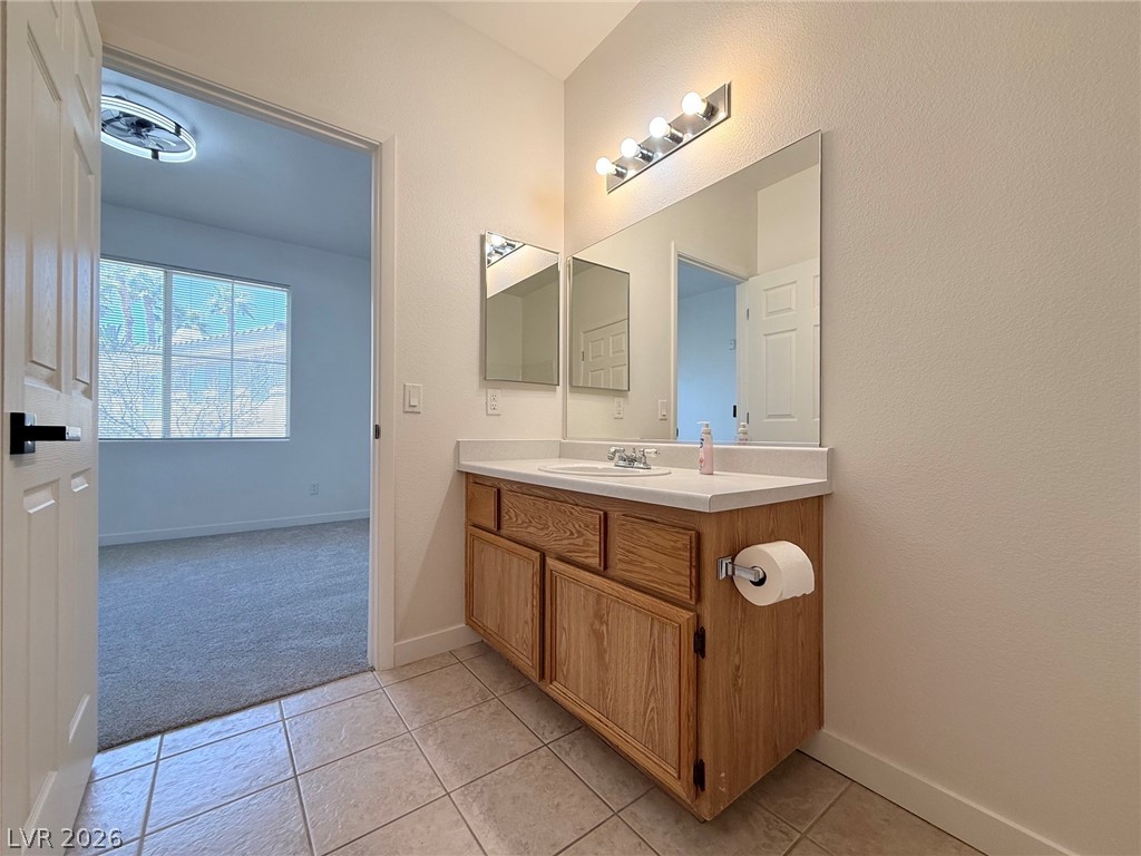 9050 West Warm Springs Road, Unit 2002 Las Vegas, NV 89148 - Photo 33 of 46 This bathroom features a single vanity, tile flooring, and provides access to an adjacent room.