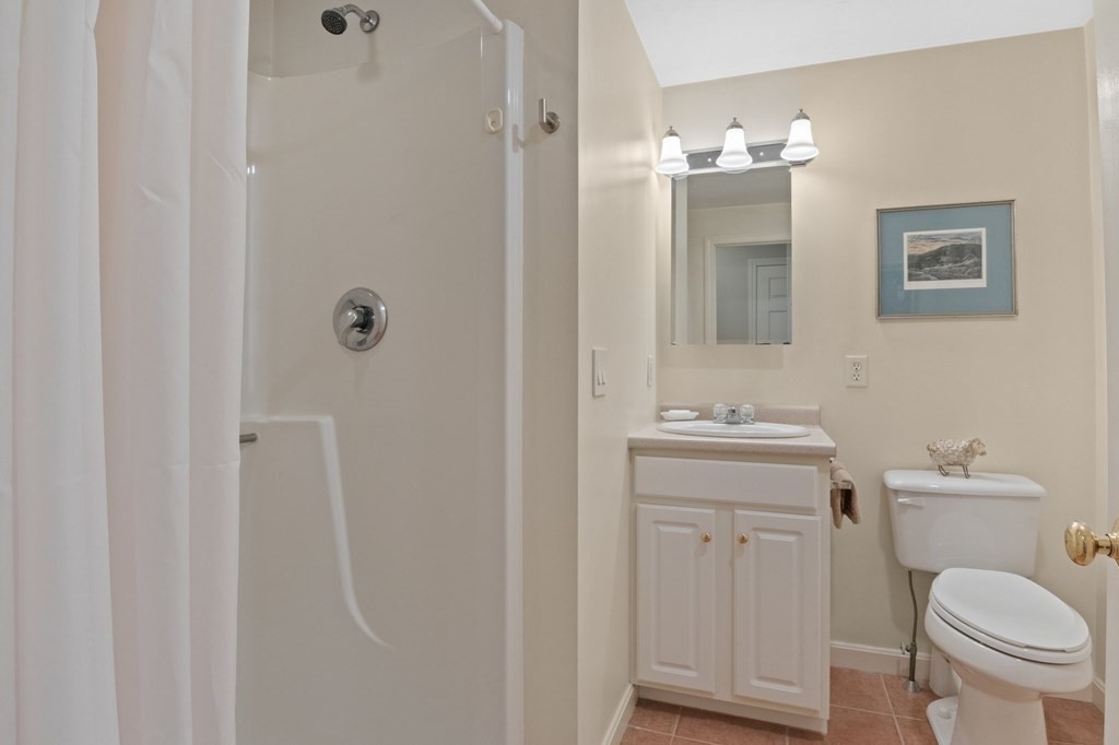 5 Woods Edge Lane, Unit 5 Mashpee, MA 02649 - Photo 11 of 29 a bathroom with a sink a toilet and mirror