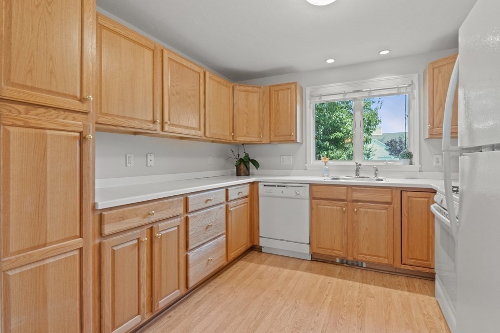 5 Woods Edge Lane, Unit 5 Mashpee, MA 02649 - Photo 6 of 29 a kitchen with granite countertop white cabinets sink and white appliances