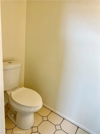 a white toilet sitting next to a white wall