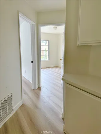 a view of a hallway with wooden floor