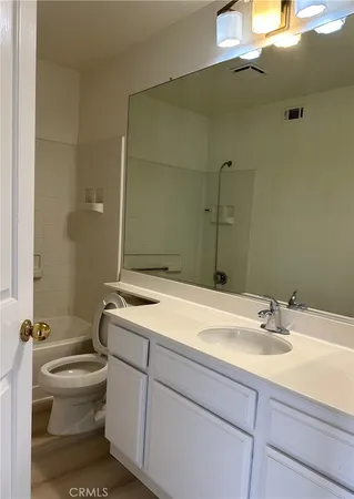 a bathroom with a sink a toilet and mirror
