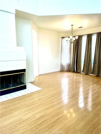 a view of a room with wooden floor and a fireplace