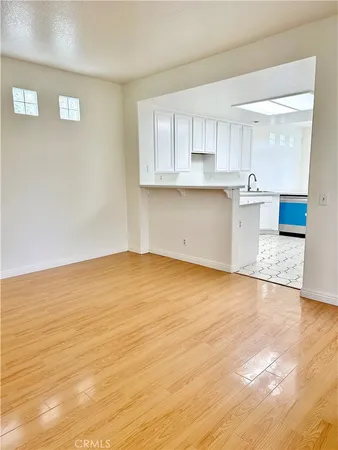 a view of a kitchen with wooden floor and electronic appliances