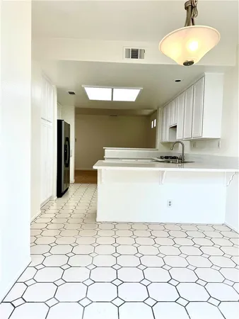 a view of a kitchen with kitchen island a sink stainless steel appliances and cabinets