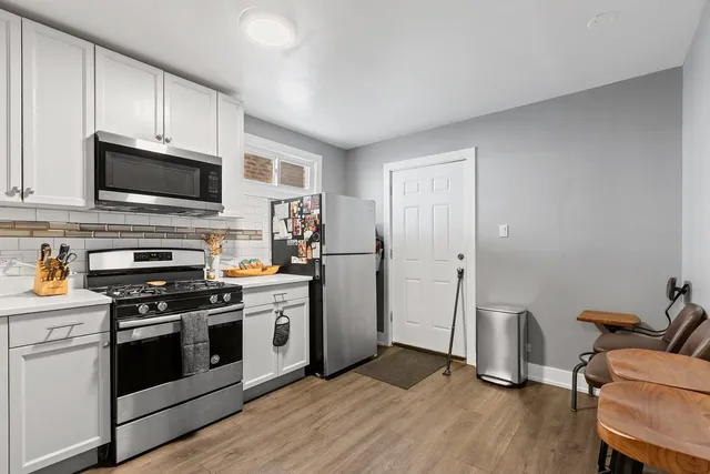 a kitchen with wooden floors and stainless steel appliances