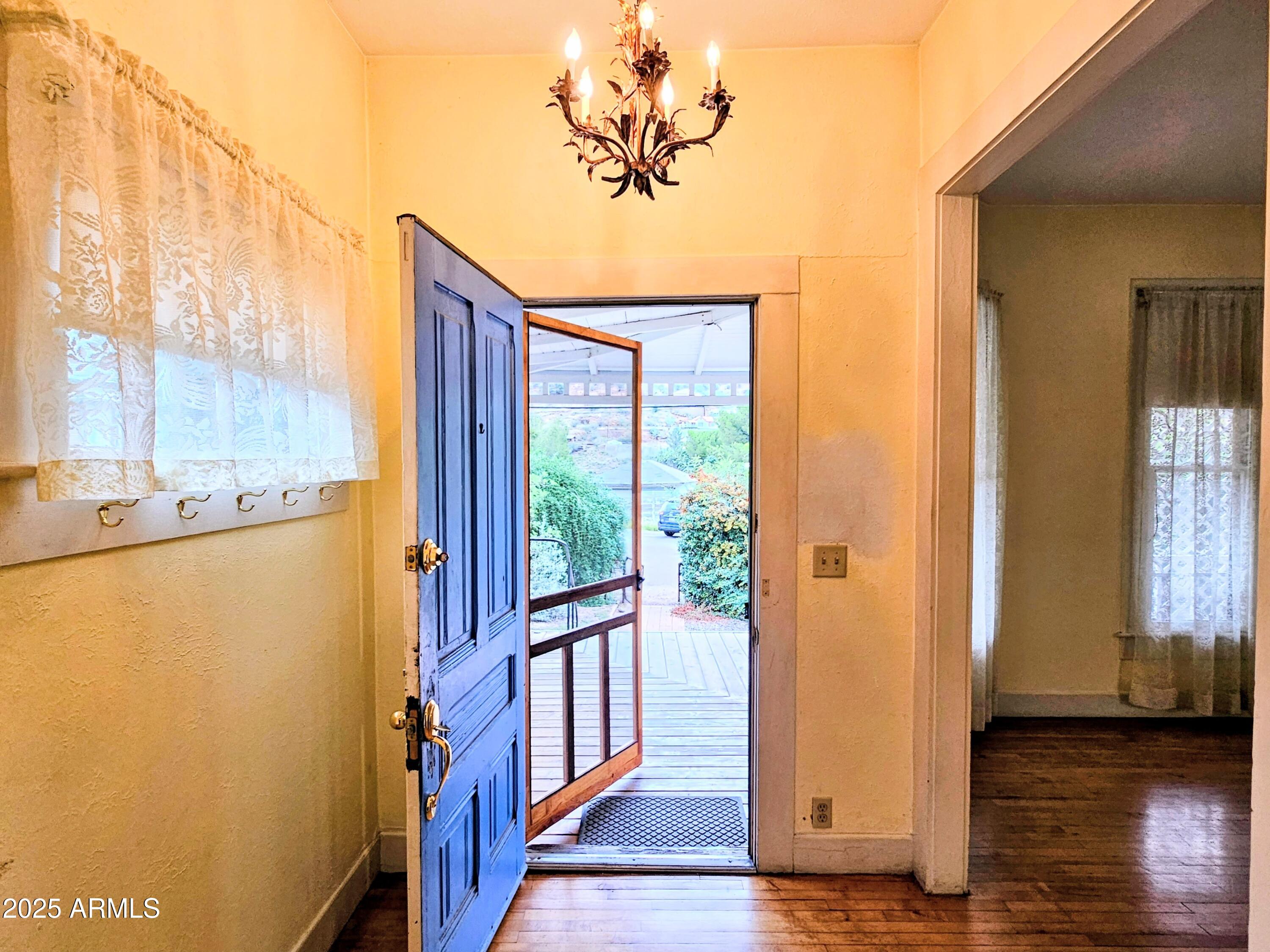 164 Quality Hill Road Bisbee, AZ 85603 - Photo 3 of 36 a view of a hallway with wooden floor and a dining room
