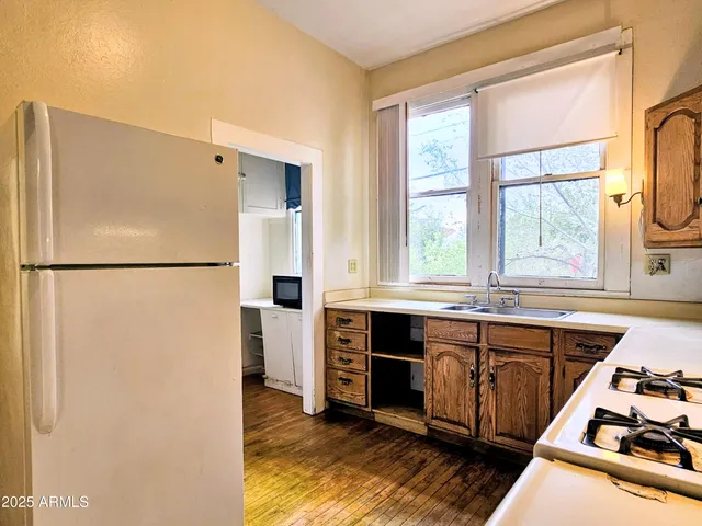 a kitchen with stainless steel appliances granite countertop a refrigerator a sink and a stove