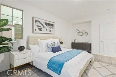 a bedroom with bed and a painting on the wall