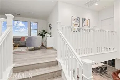 a view of staircase with furniture and lots of frames on wall
