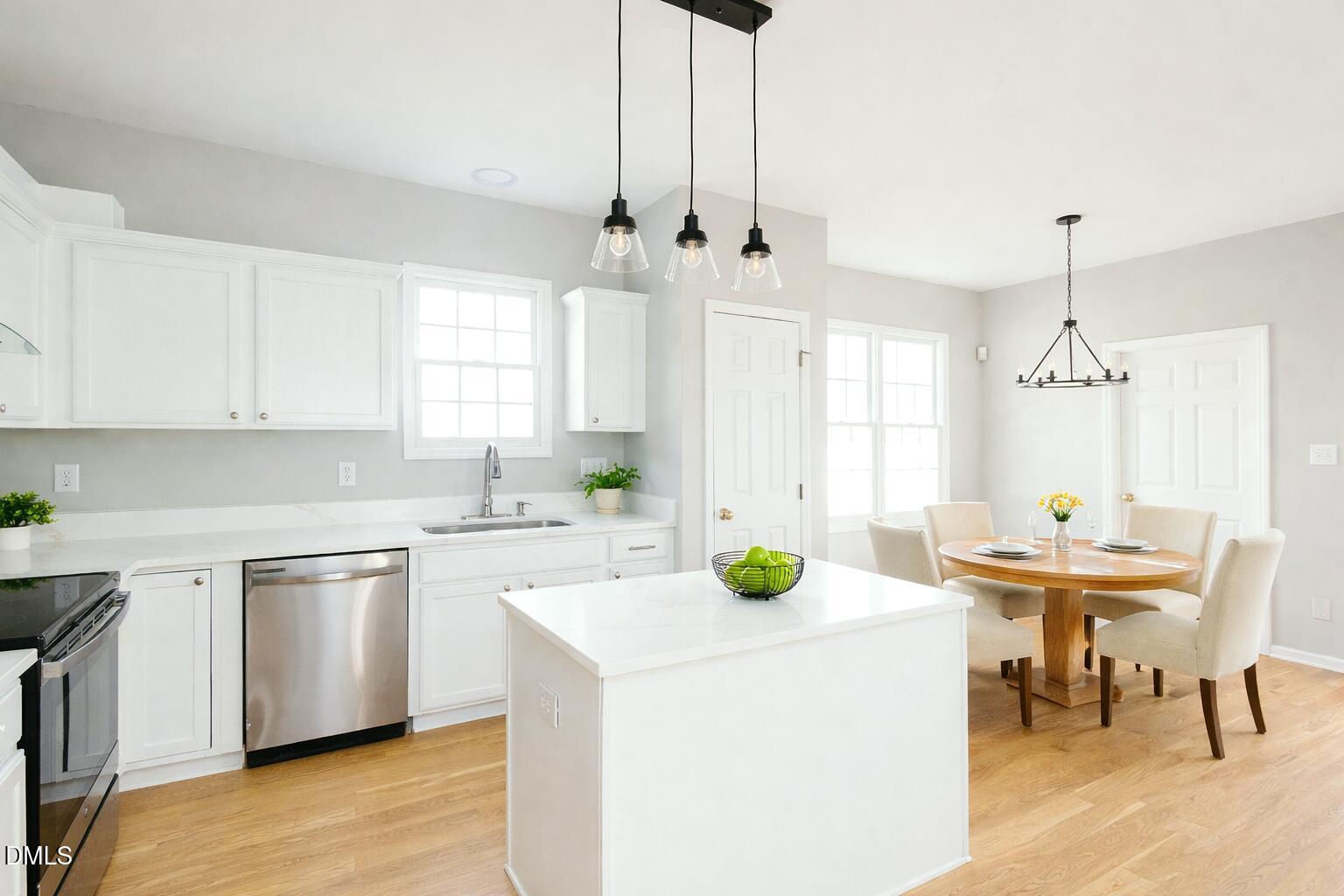 115 Chancellors Ridge Drive Durham, NC 27713 - Photo 16 of 57 a kitchen with stainless steel appliances kitchen island a table chairs and a refrigerator