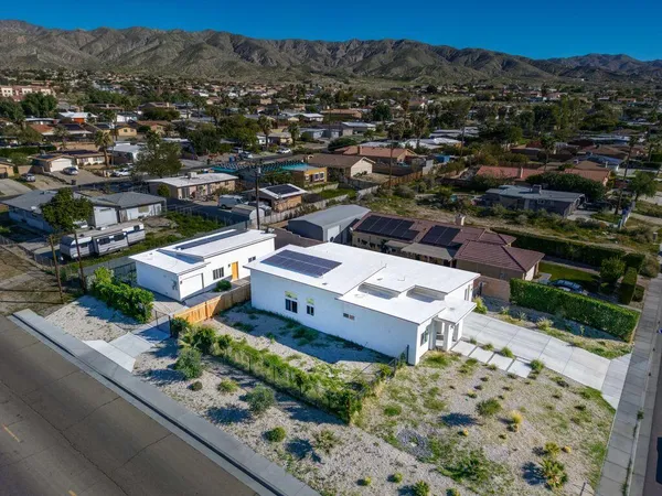 an aerial view of a house with a mountain