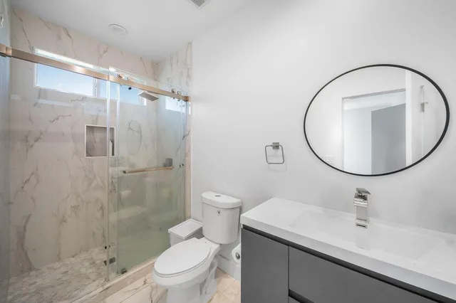 a bathroom with a sink a toilet and a mirror