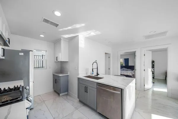 a kitchen with stainless steel appliances granite countertop a sink stove and refrigerator