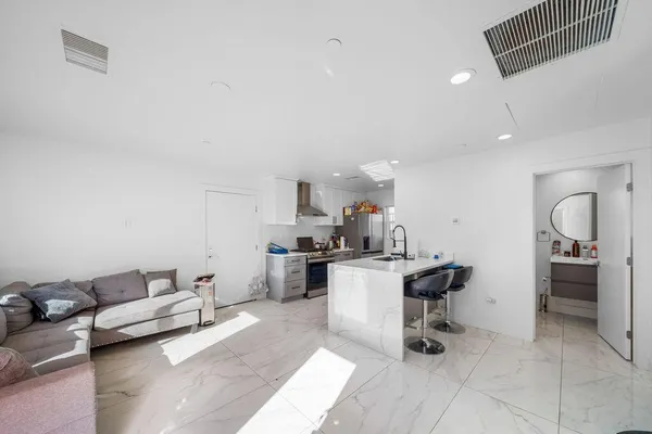 a living room with furniture and view of kitchen