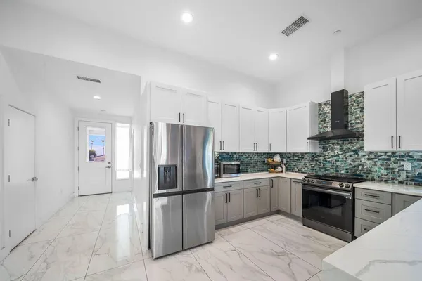 a kitchen with stainless steel appliances a refrigerator sink and cabinets