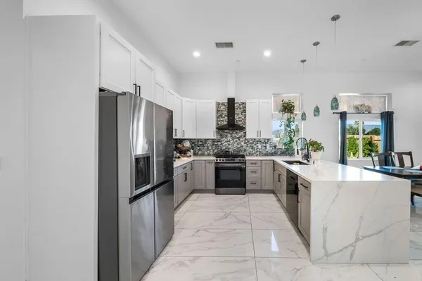 a kitchen with stainless steel appliances a refrigerator sink and stove