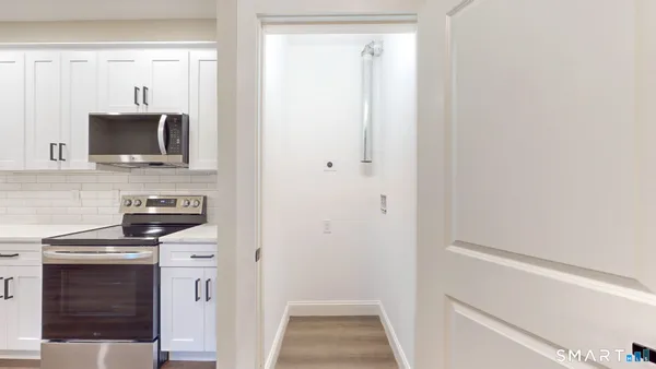 a kitchen with white cabinets and stainless steel appliances