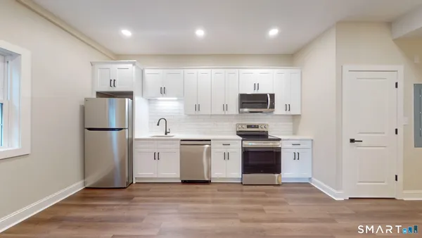 a kitchen with stainless steel appliances granite countertop a refrigerator and a stove top oven