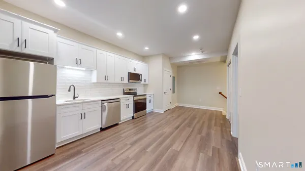a kitchen with white cabinets and white appliances