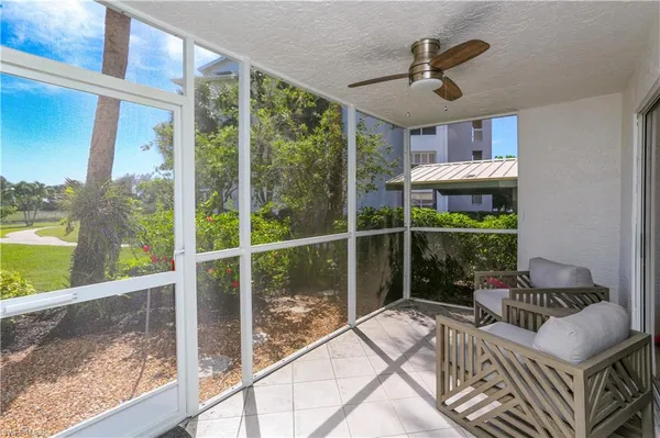 a view of a porch with furniture and floor to ceiling windows