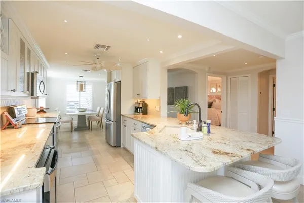 a kitchen with a sink and chairs