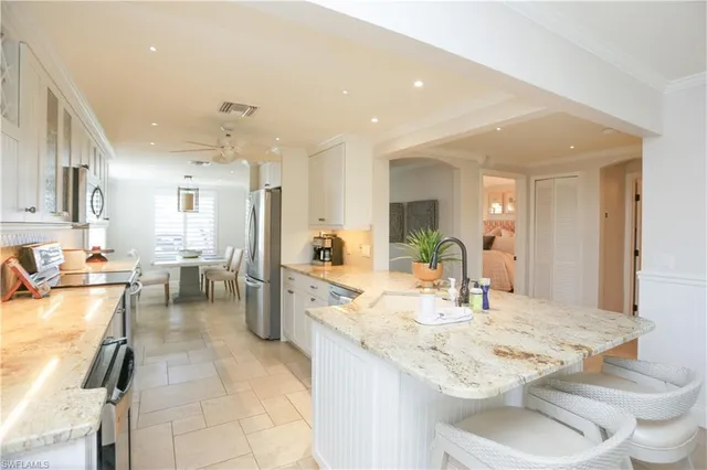 a kitchen with a sink and chairs
