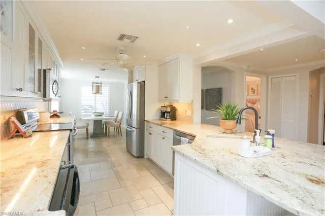 a large kitchen with granite countertop lots of counter top space and living room