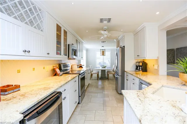 a large kitchen with kitchen island a sink stainless steel appliances and cabinets