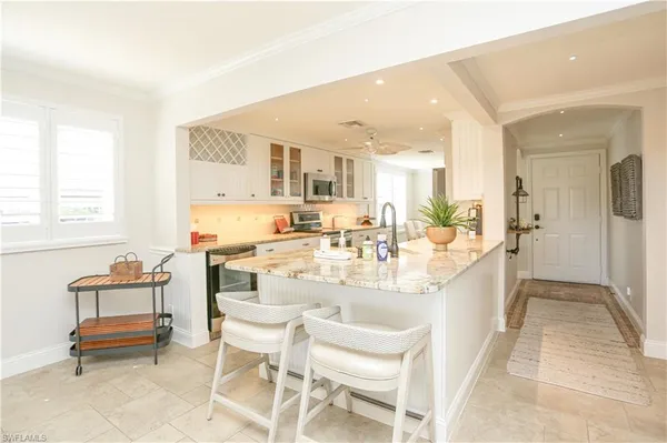 a large white kitchen with a table and chairs