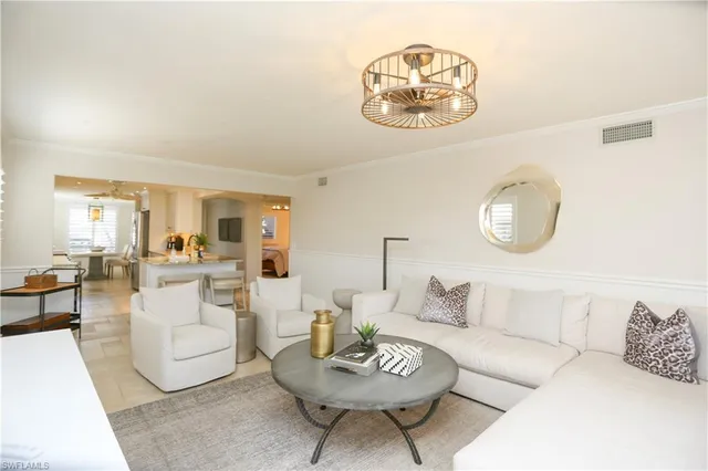 a living room with furniture a rug and a mirror